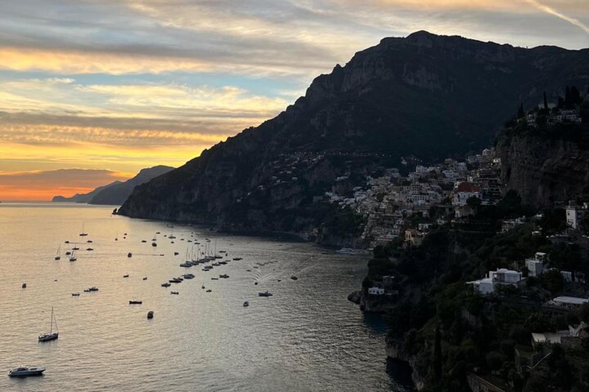 Un grupo de barcos en el agua al atardecer