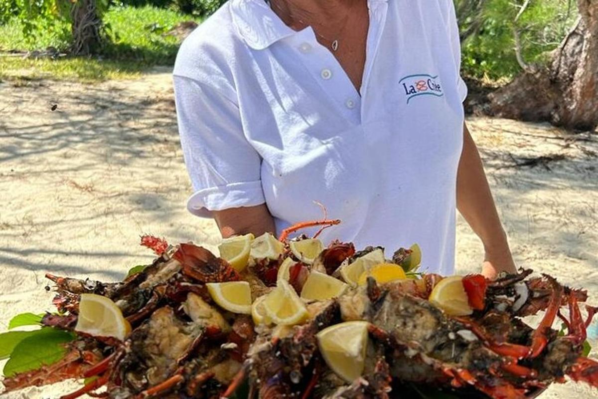 una donna che tiene in mano un granchio con sopra delle fette di limone