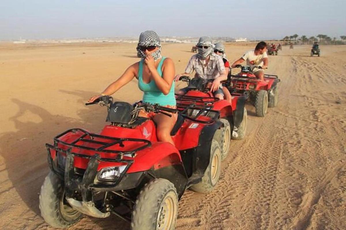 Un grupo de personas conduciendo vehículos todo terreno en el desierto.