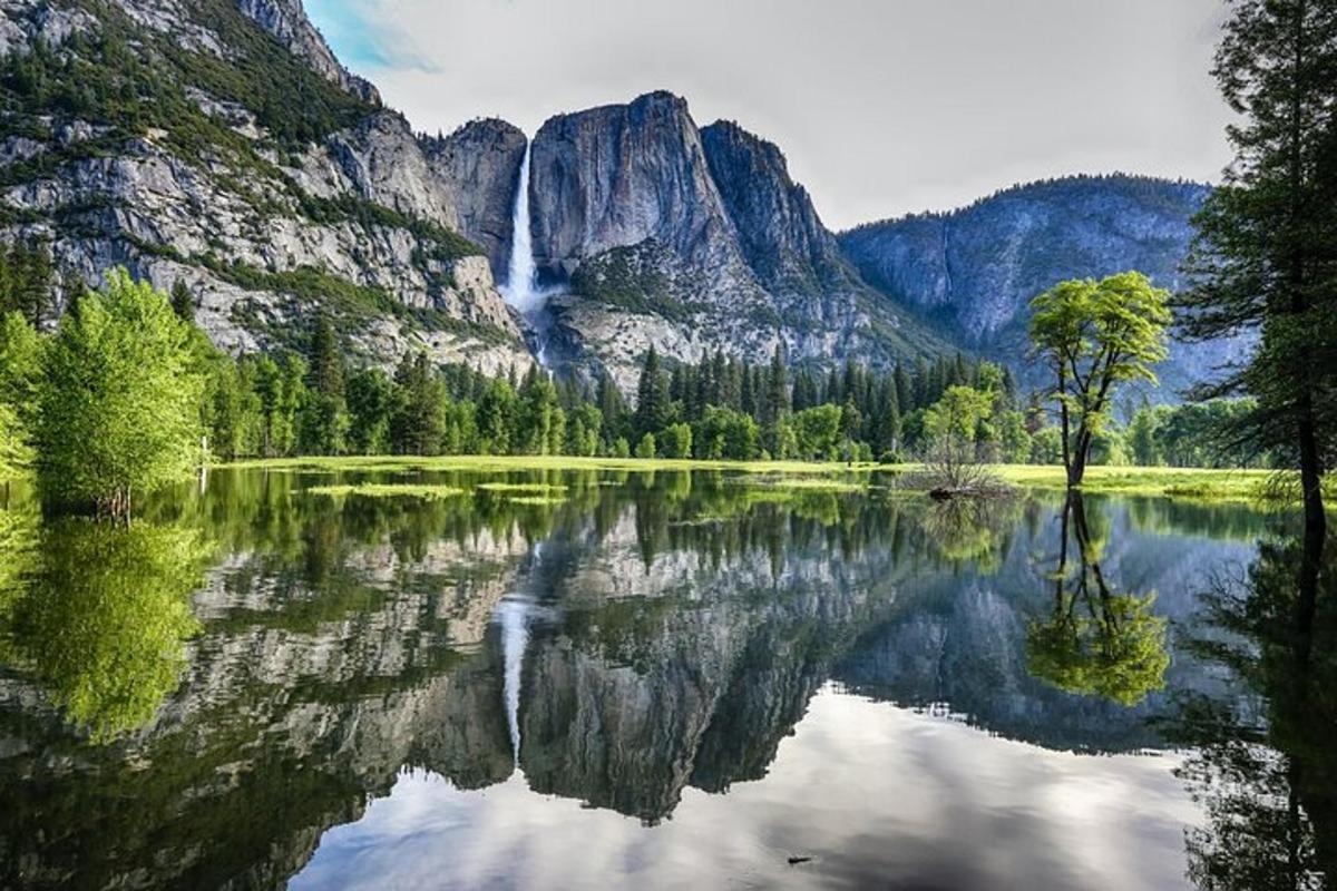 a waterfall and a lake in front of a mountain