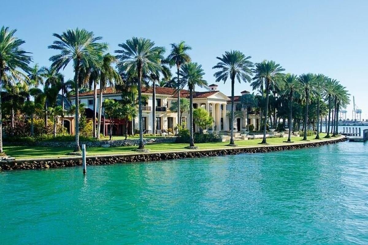 una casa con palme di fronte a uno specchio d'acqua
