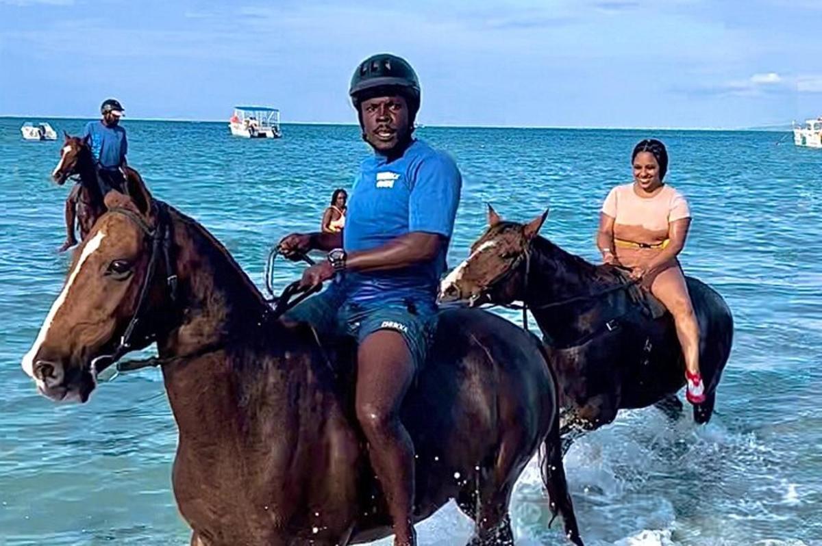 sekumpulan orang menunggang kuda di pantai