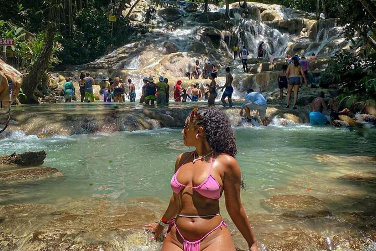 una donna in bikini in piedi davanti a una cascata