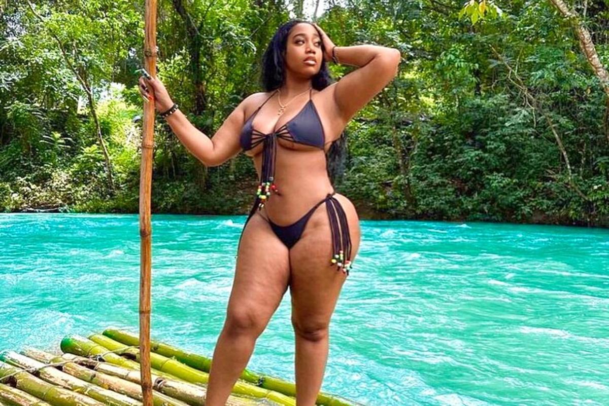 una donna in bikini in piedi su una zattera in acqua