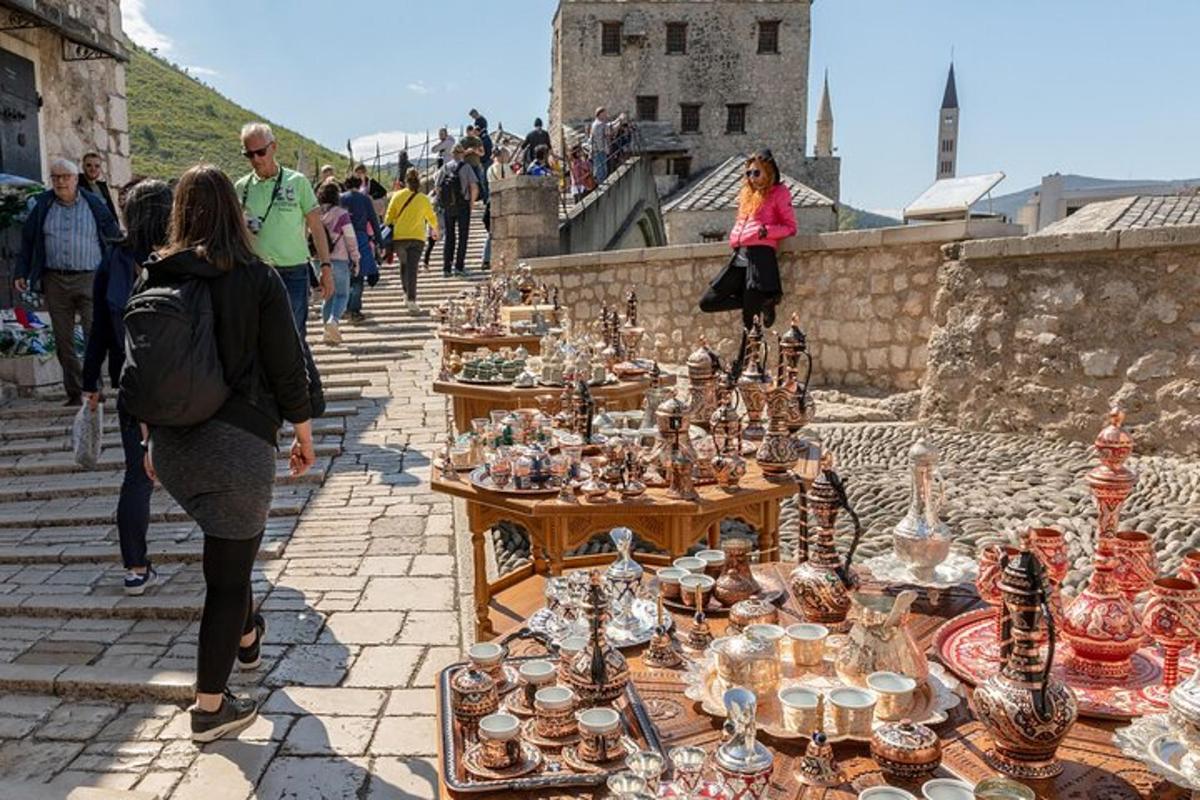 skupina lidí procházejících se kolem vystavených skleněných předmětů
