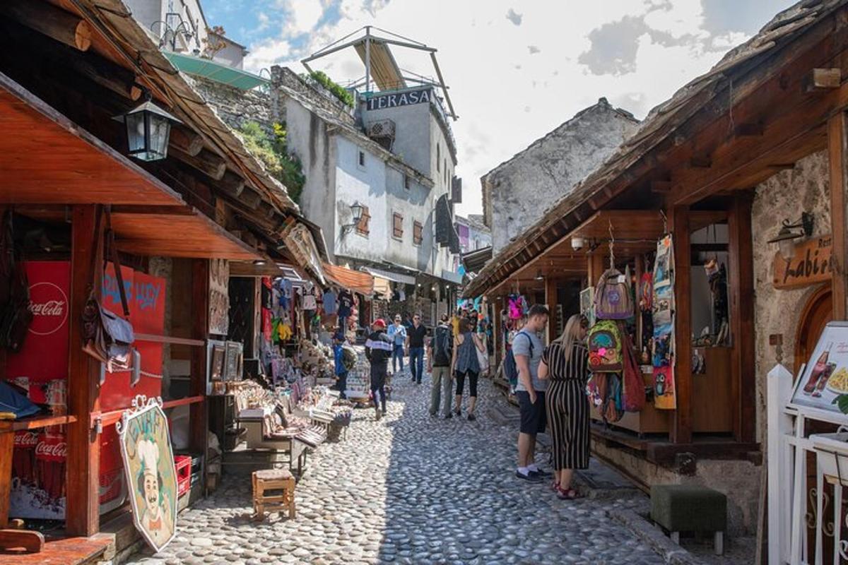 skupina lidí procházejících se ulicí s obchody