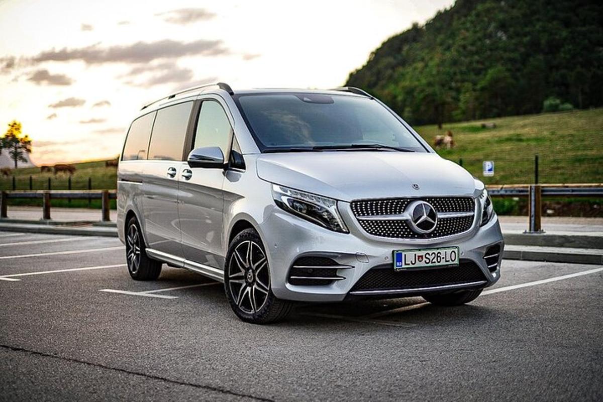 Bílá dodávka Mercedes Benz zaparkovaná na parkovišti