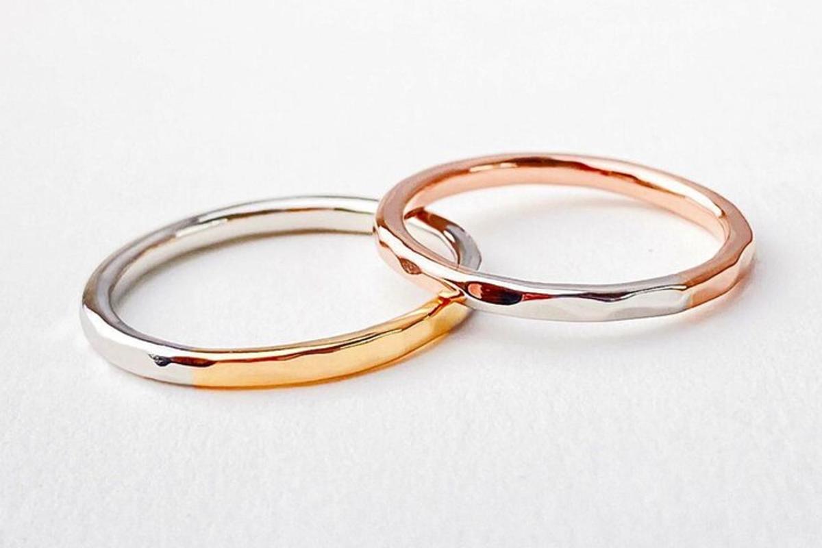 two gold rings sitting next to each other