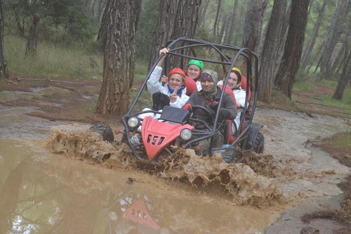eine Gruppe von Menschen, die auf einem Quad im Schlamm fahren