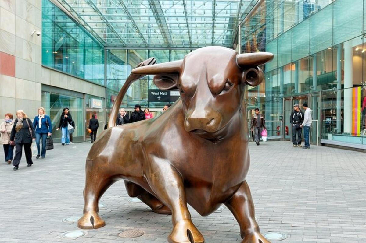 una statua in bronzo di un toro di fronte a un edificio