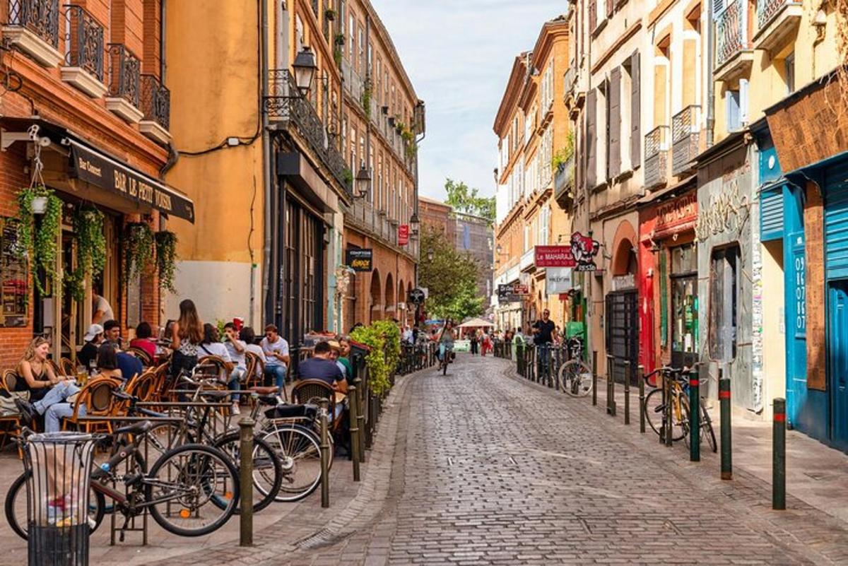 un gruppo di persone sedute ai tavoli in una strada cittadina