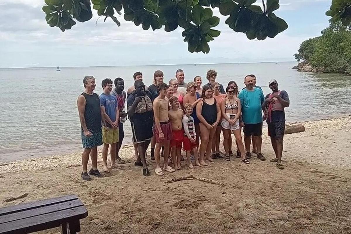 a group of people posing for a picture on the beach