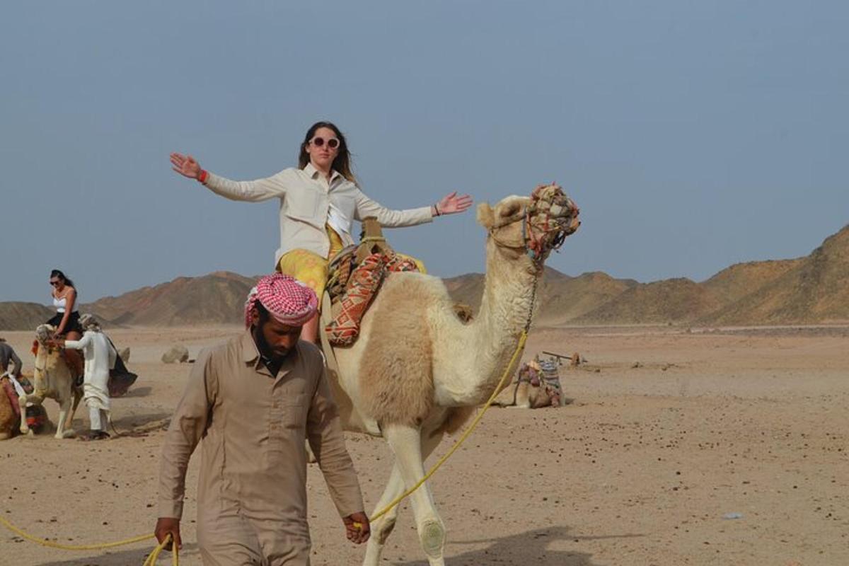 a woman riding on a camel in the desert