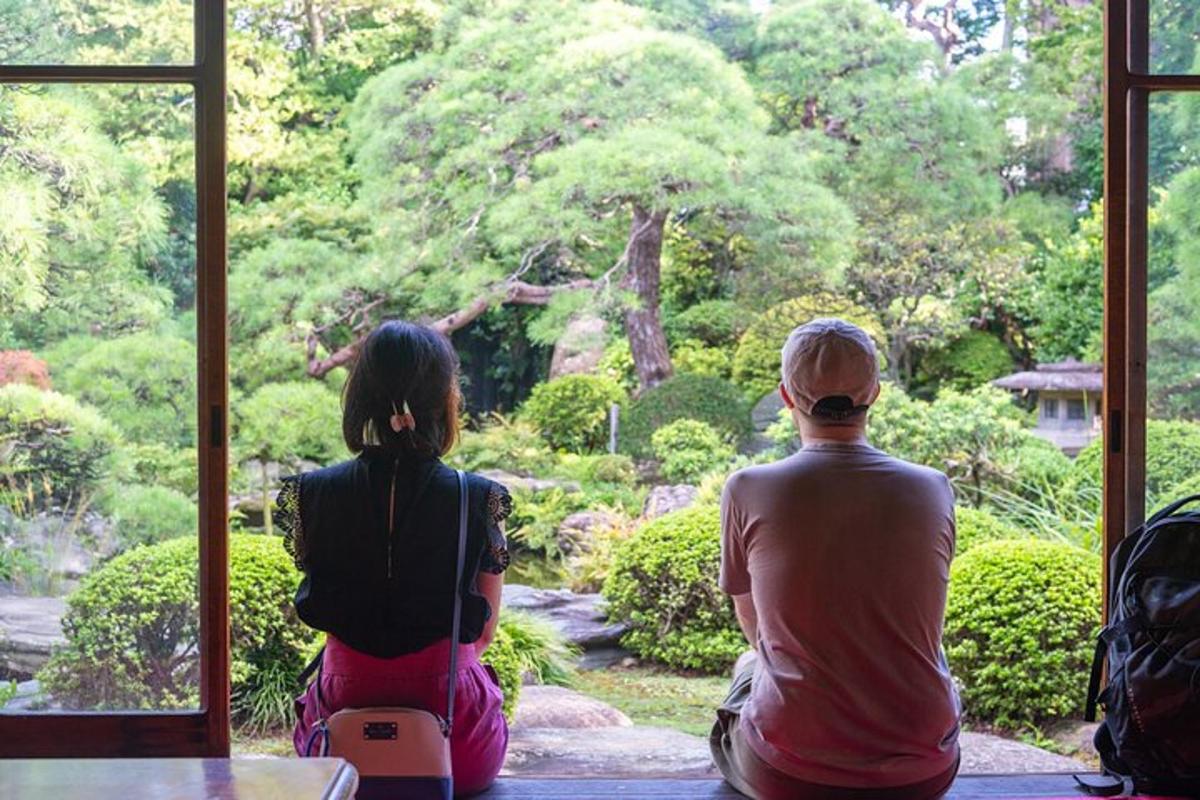 un uomo e una donna che guardano fuori da una finestra verso un giardino