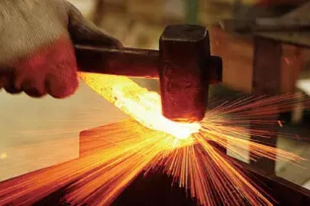 a person cutting a piece of metal with a machine