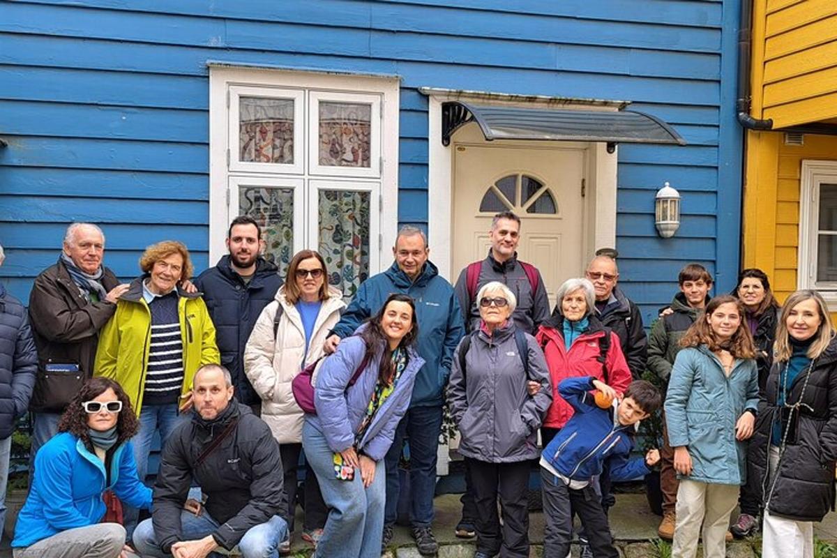 eine Gruppe von Menschen steht vor einem blauen Haus