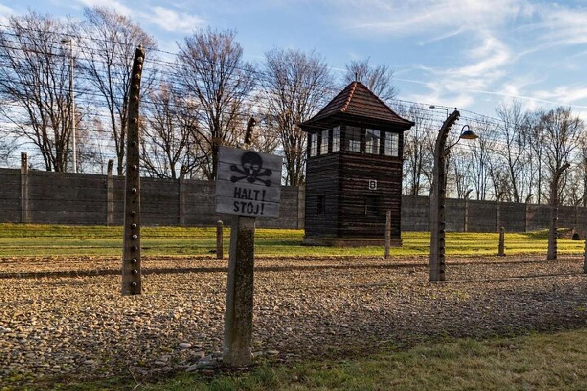 a sign in a field with a small building