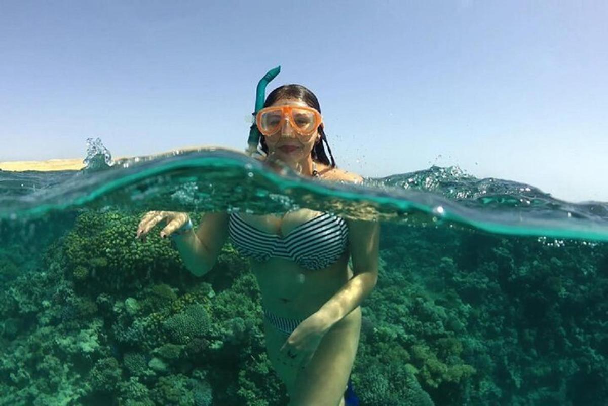 o femeie în costum de baie și ochelari de protecție înotând în ocean