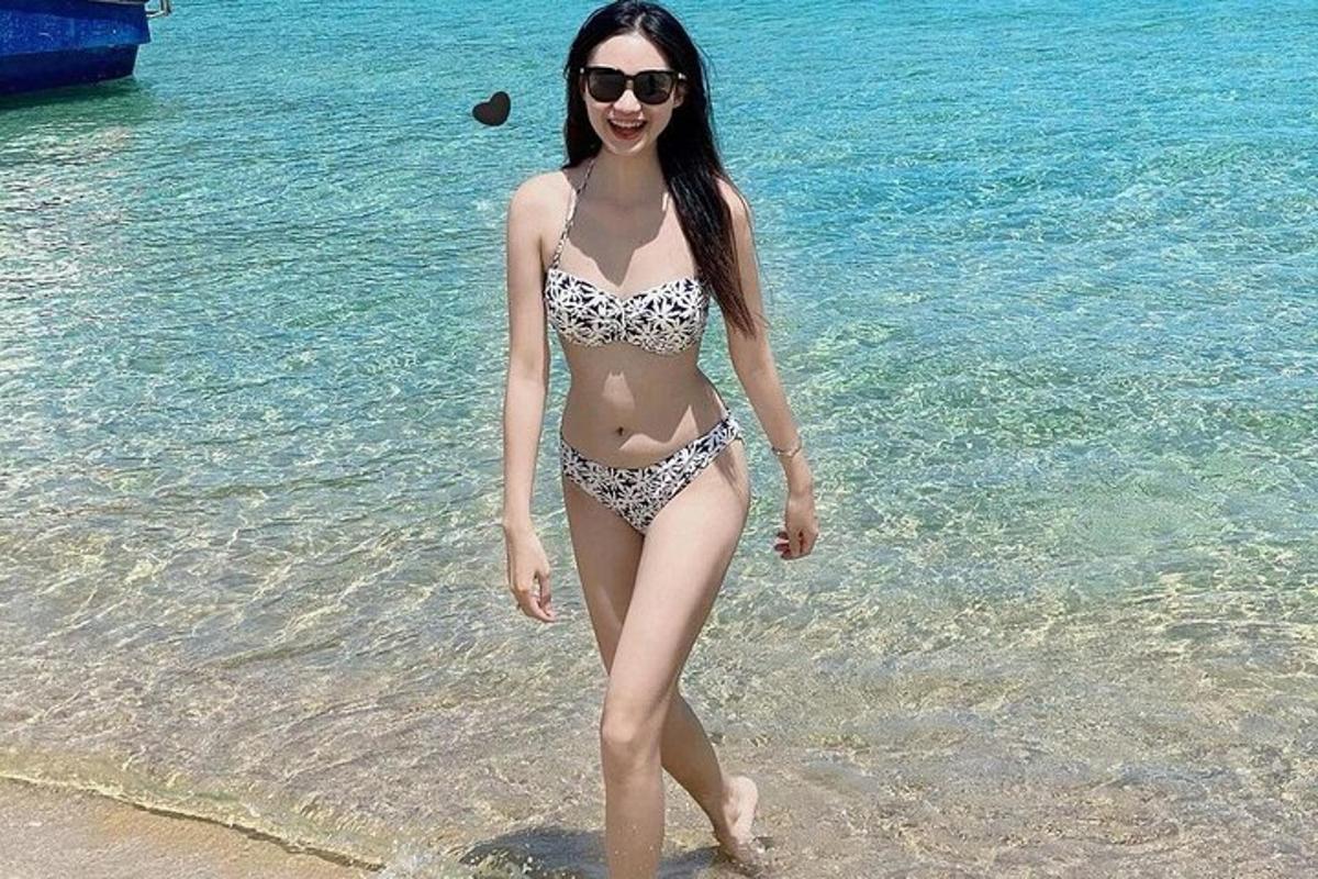 uma mulher de biquíni em pé na praia