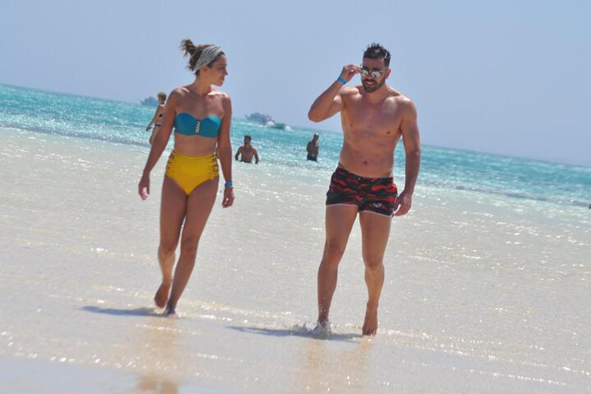 un uomo e una donna che camminano sulla spiaggia
