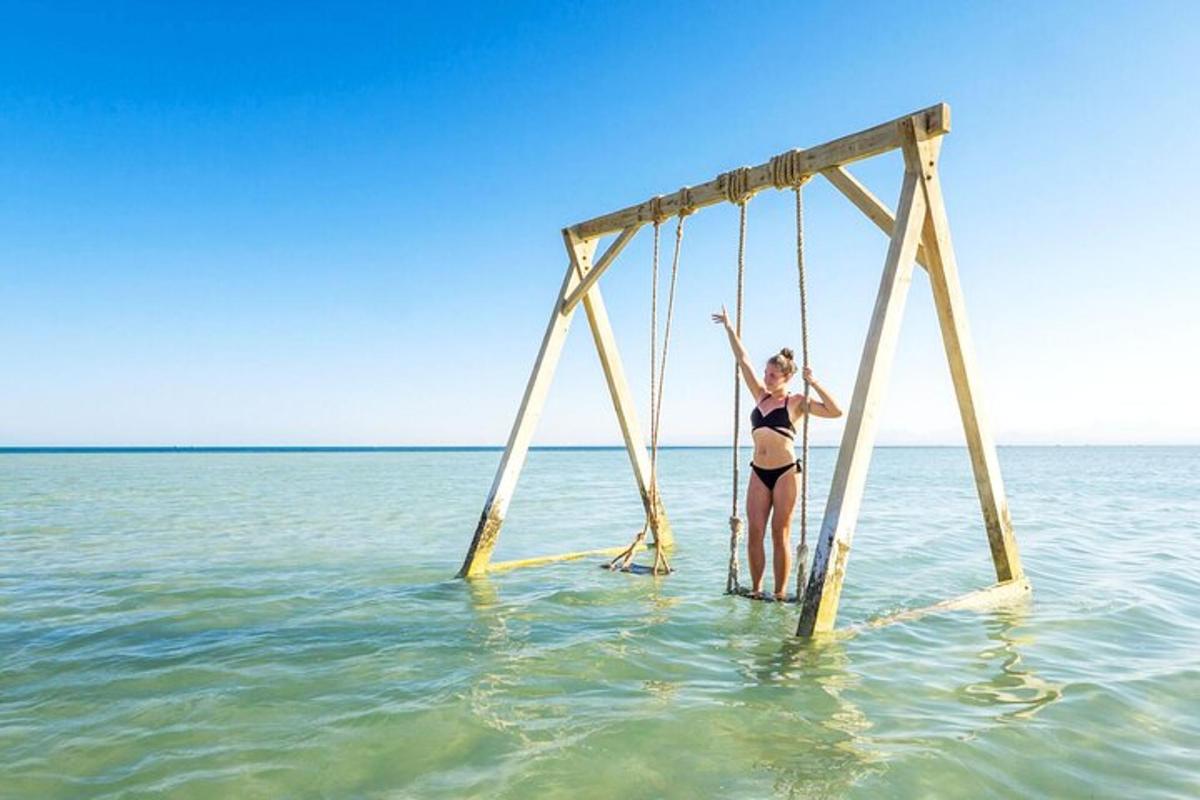 una donna è su un'altalena nell'acqua