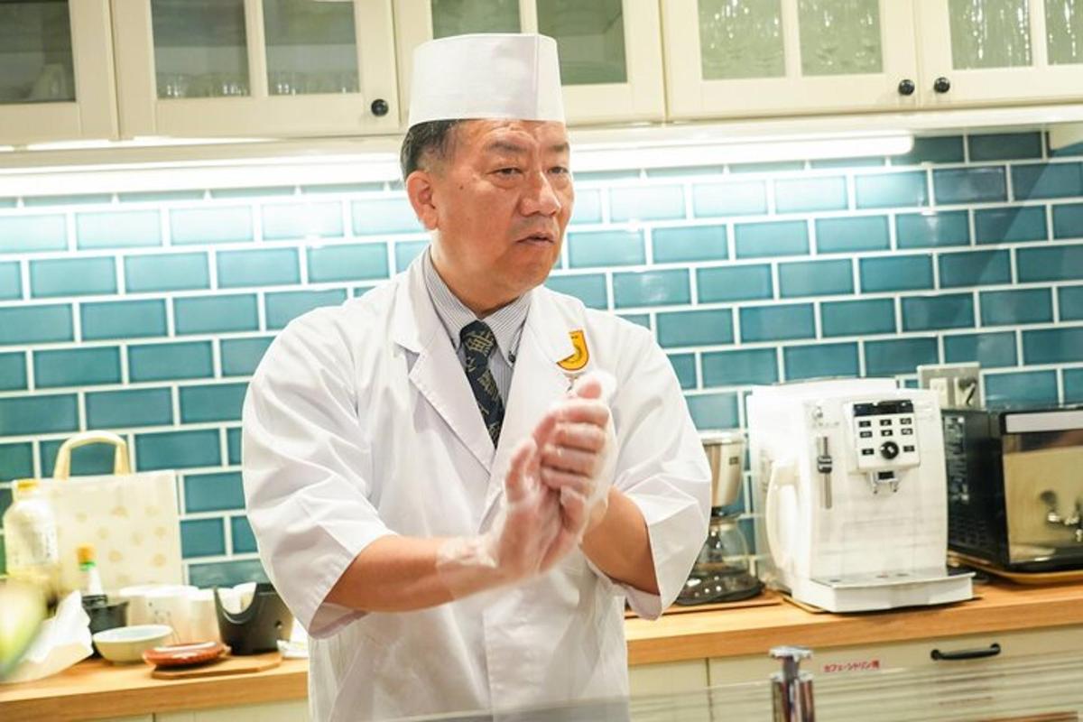 a man in a chefs hat standing in a kitchen