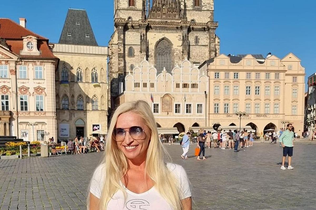 uma mulher parada numa praça em frente a um prédio