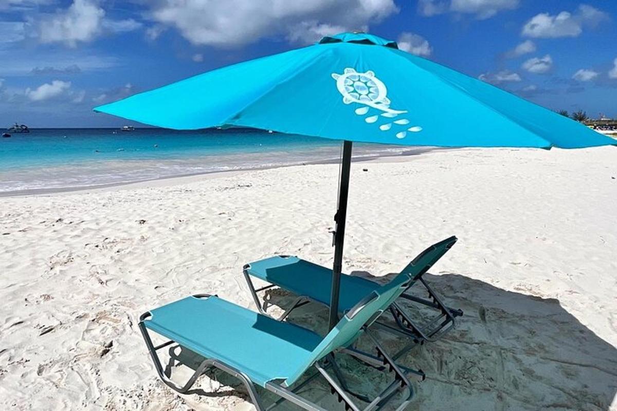 ein blauer Stuhl und ein Sonnenschirm am Strand