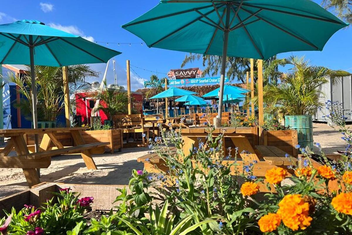 eine Terrasse mit Tischen, Sonnenschirmen und Blumen