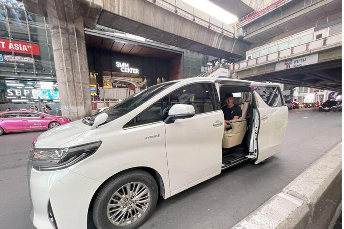 Un coche eléctrico blanco circulando por una calle de la ciudad.