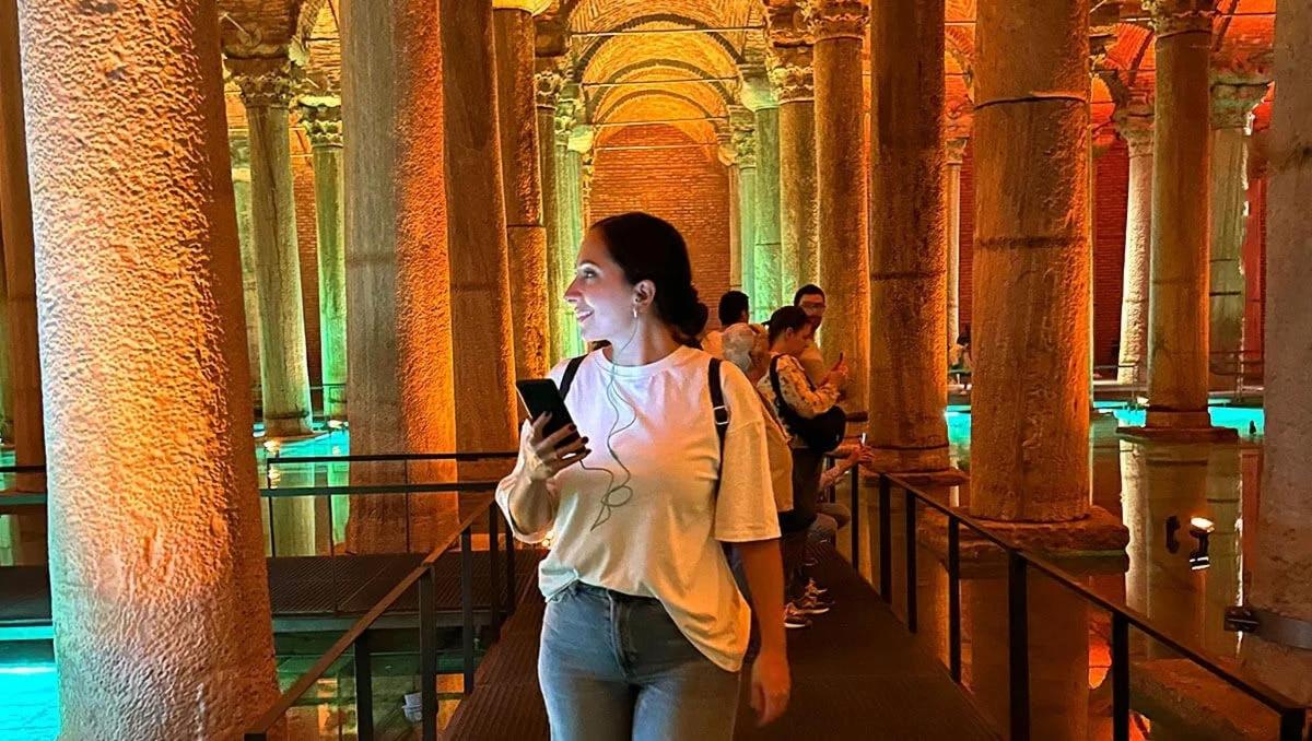 una donna che cammina in un edificio guardando il suo cellulare