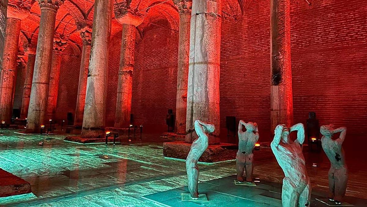 un gruppo di statue in un edificio con luci rosse