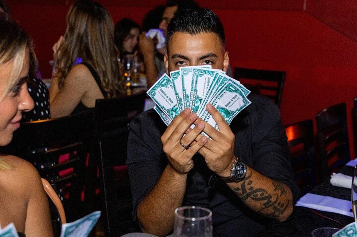 mees, kes hoiab üleval dollariliste rahatähtede lehvikut