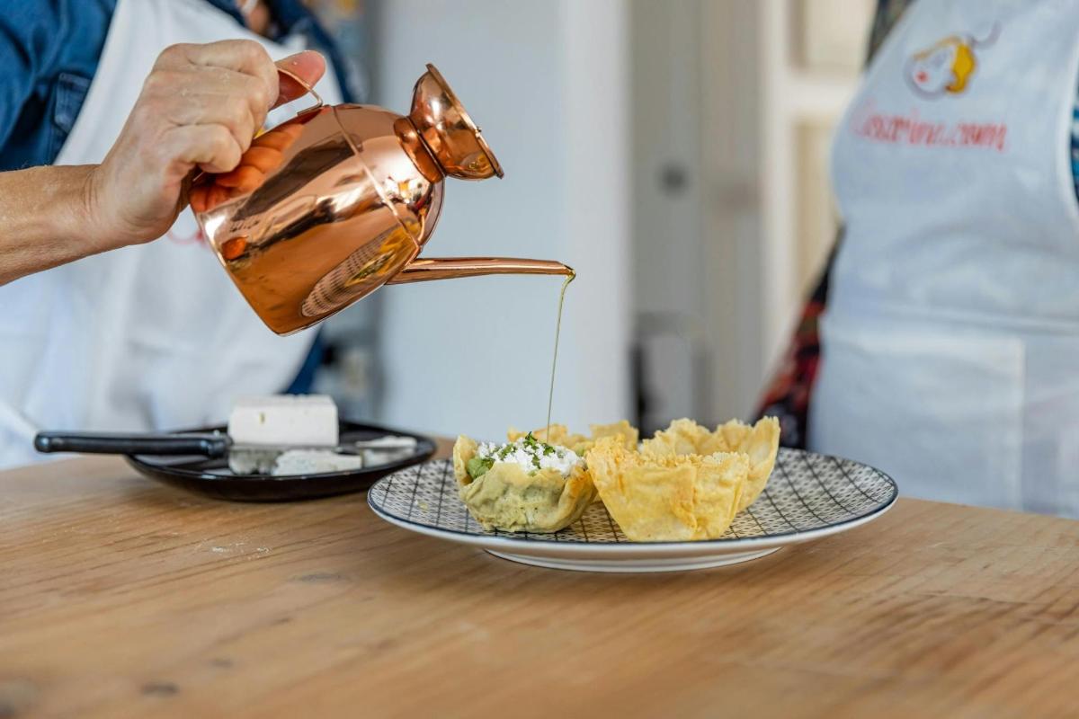 una persona che versa il cibo in una pentola su un tavolo