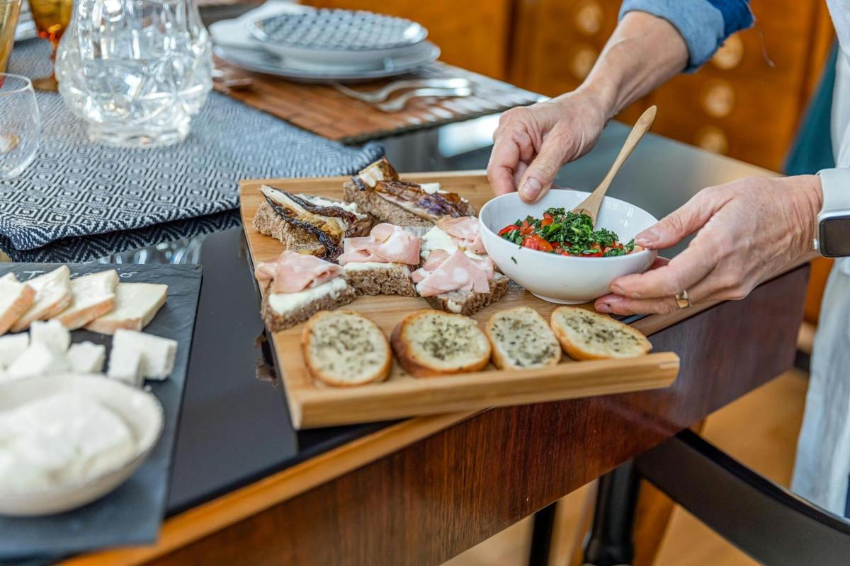una persona che tiene una ciotola di cibo su un tagliere