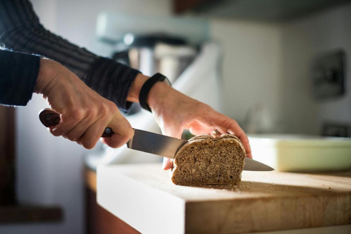 una persona cortando un trozo de pastel con un cuchillo