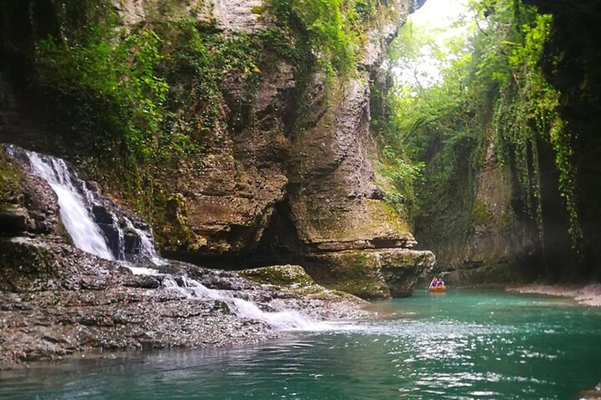 uma pessoa em um barco em um rio próximo a uma cachoeira