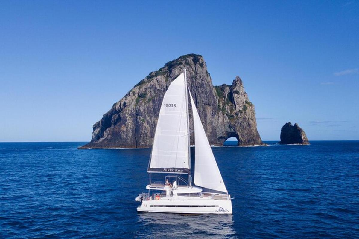 a sailboat on the water with a rock formation