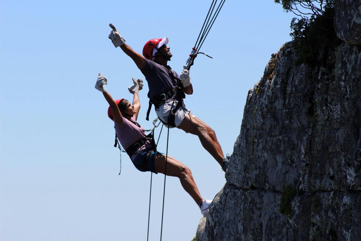 Dos personas están haciendo rappel desde un acantilado