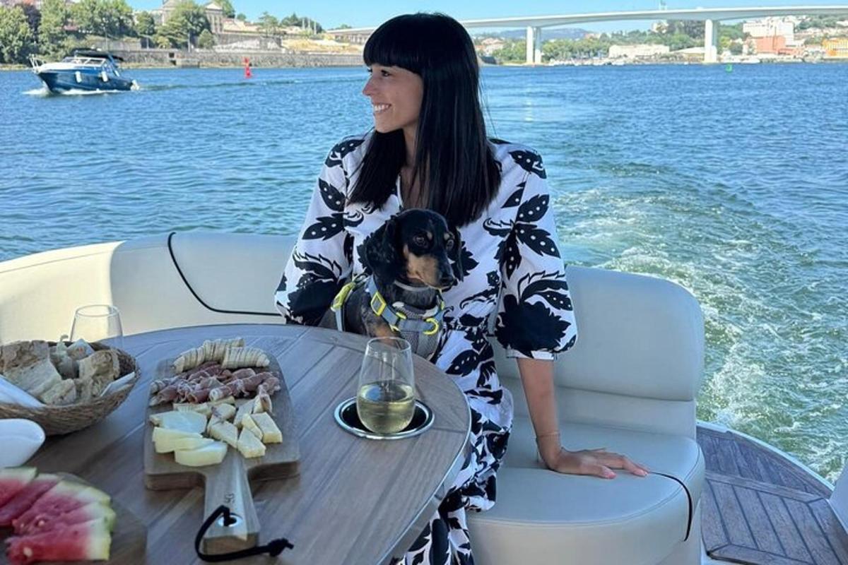 uma mulher sentada à mesa com um cachorro em um barco