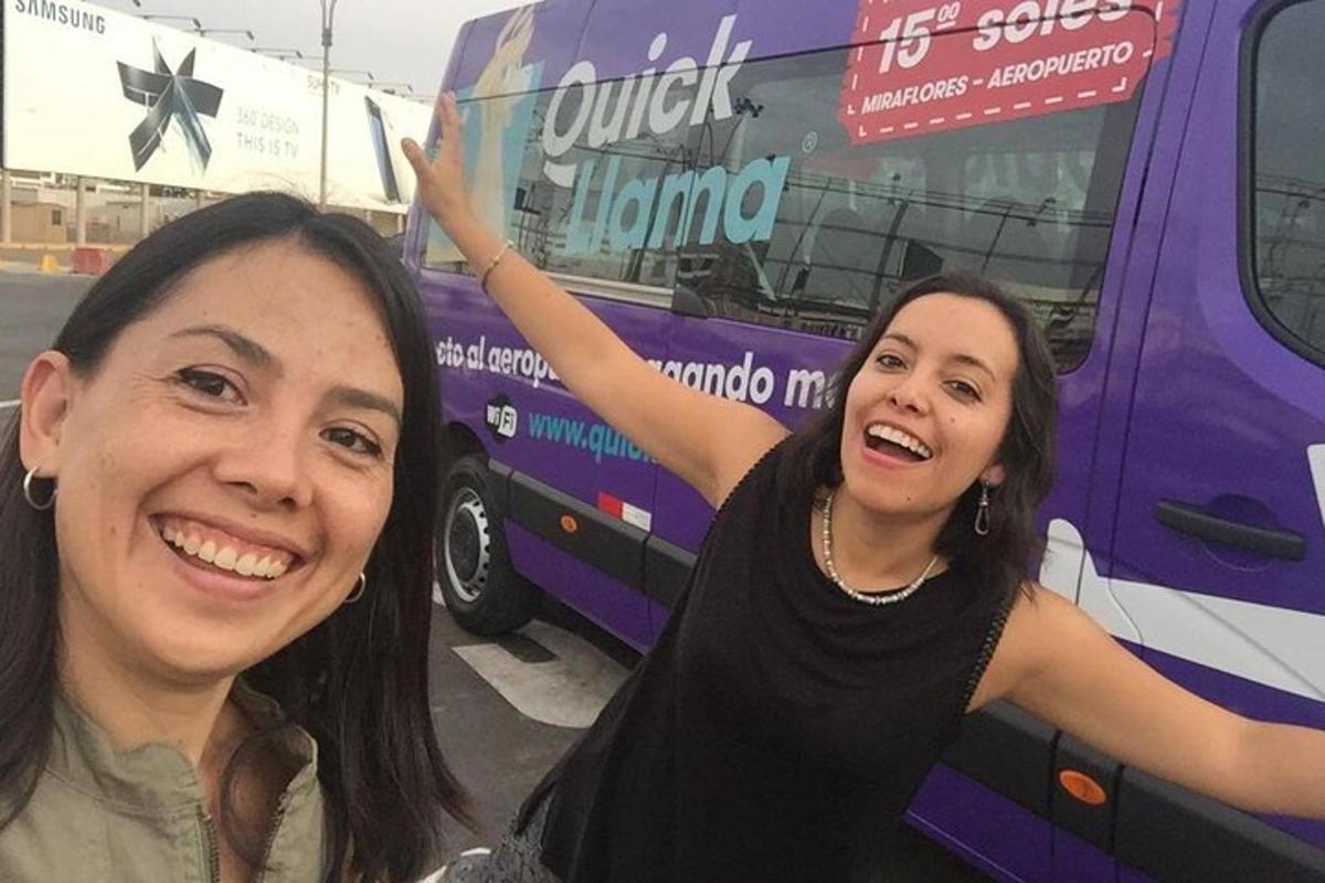 dua wanita berdiri di depan bus ungu