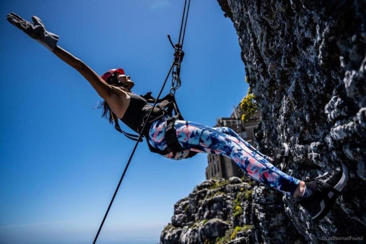 una donna è su una corda doppia su una scogliera