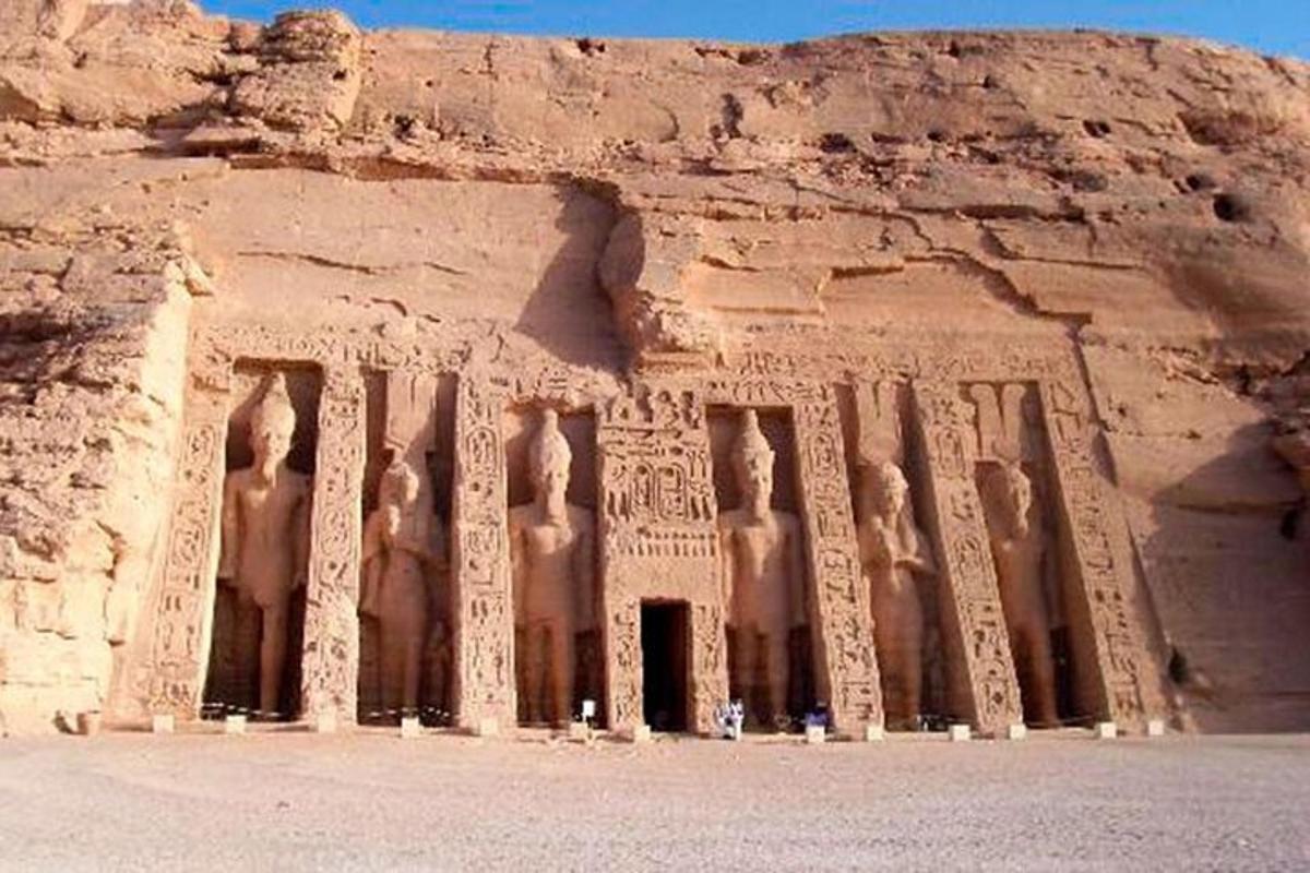 Un antiguo edificio con estatuas en la ladera de un acantilado.