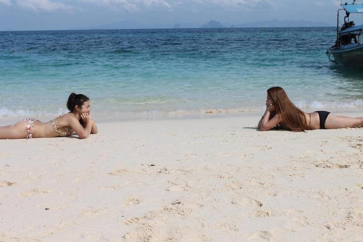 two women laying on the sand on the beach