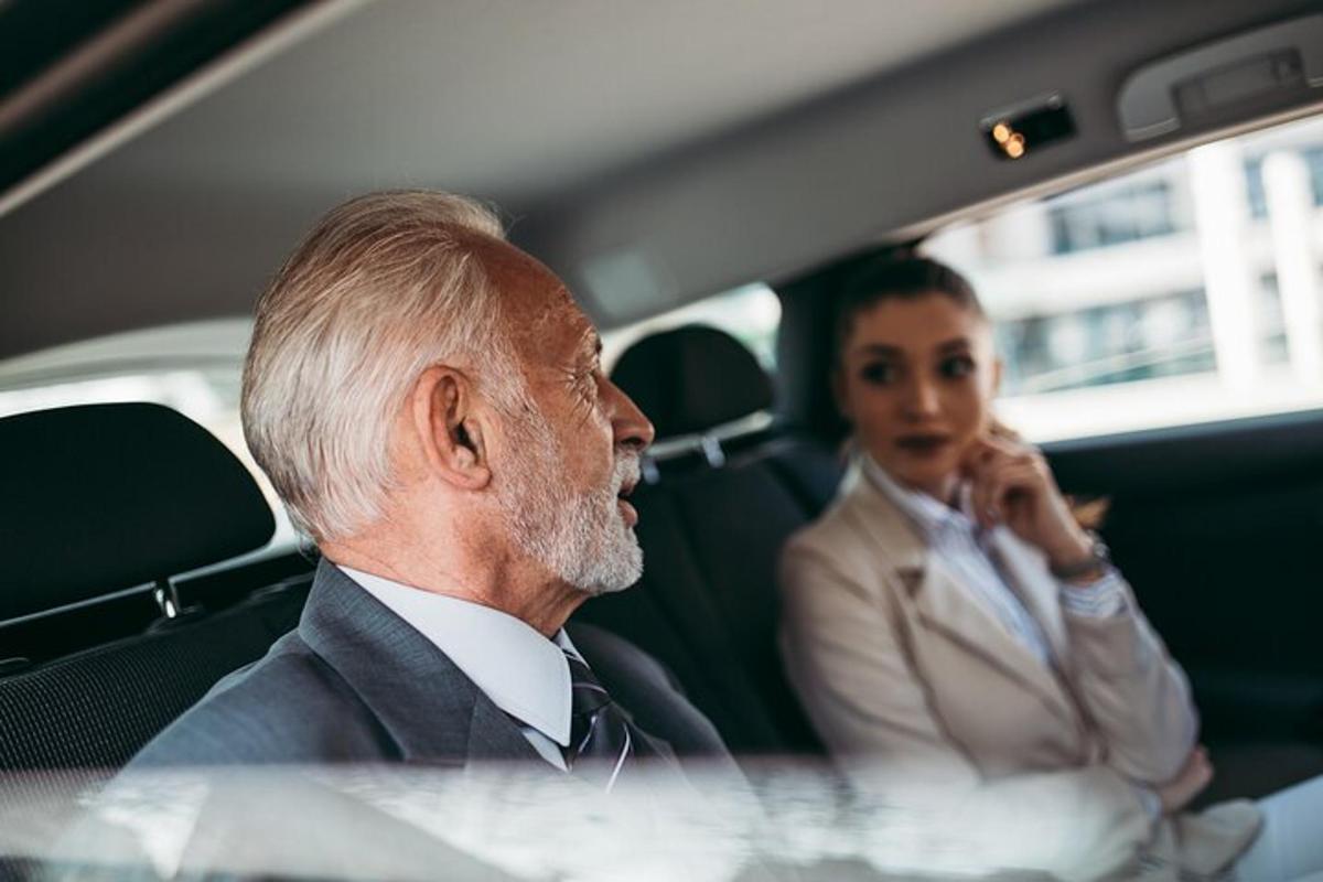 an older man and a woman sitting in a car