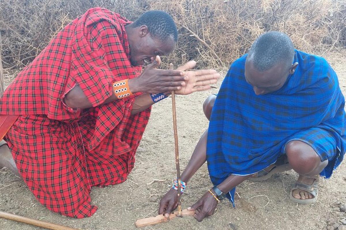two men kneeling down and playing with a stick
