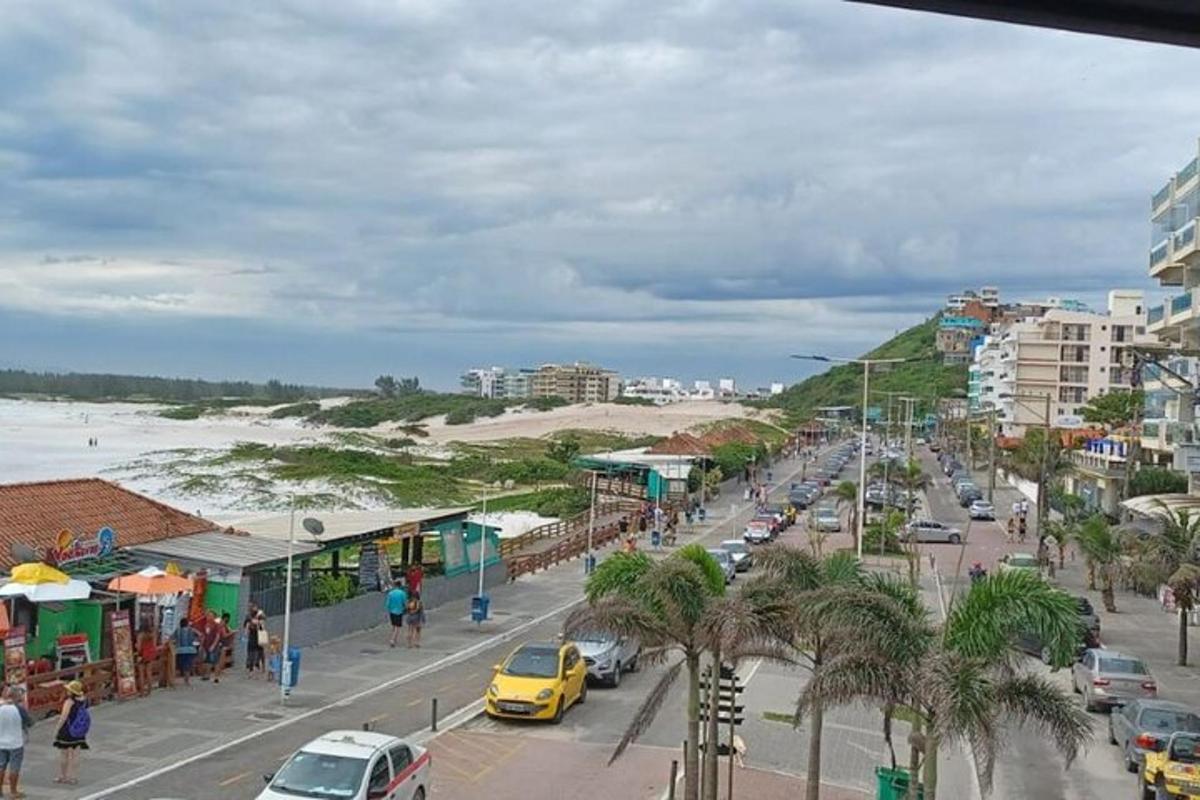 a busy city street with cars parked on a beach