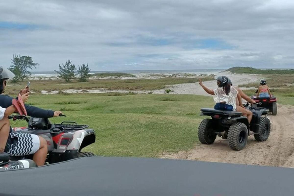 a group of people riding atvs down a dirt road
