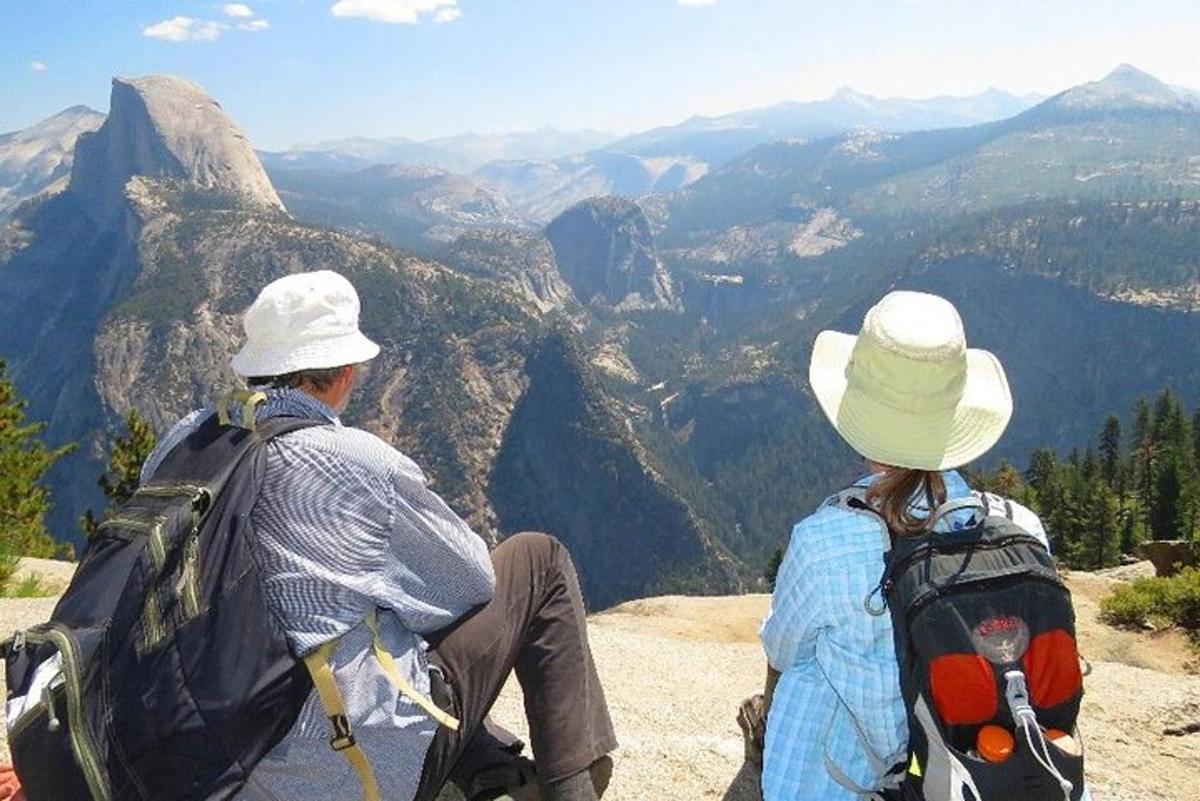 due persone sedute in cima a una montagna