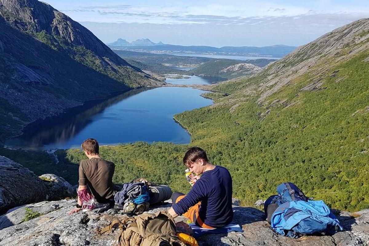 two men sitting on top of a mountain